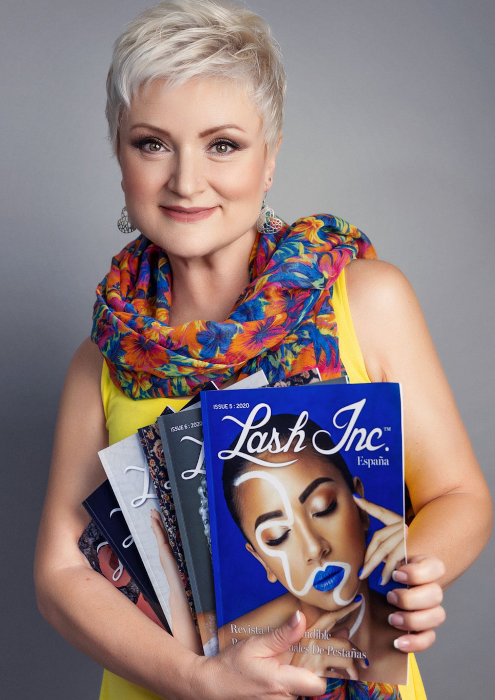 Lana Slatina sosteniendo varios ejemplares de la revista Lash Inc.